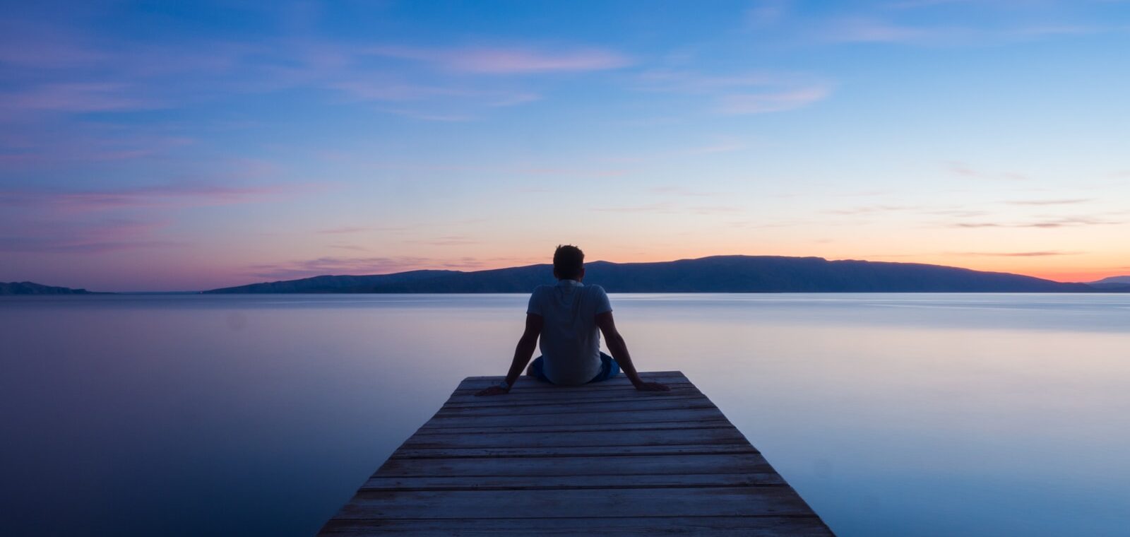 man siting on wooden dock